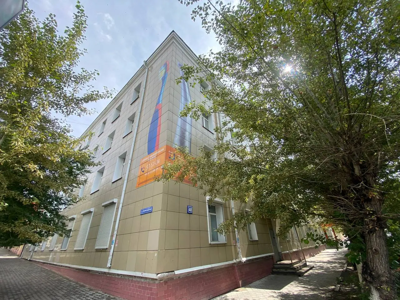 Multi-storey academy building surrounded by trees
